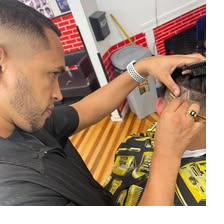 Barber Mendy giving a client a fresh fade at Unlimited Barbershop in Danbury, CT